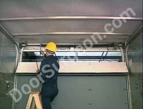 Door Surgeon rolling door serviceman repairing truck rolling door.